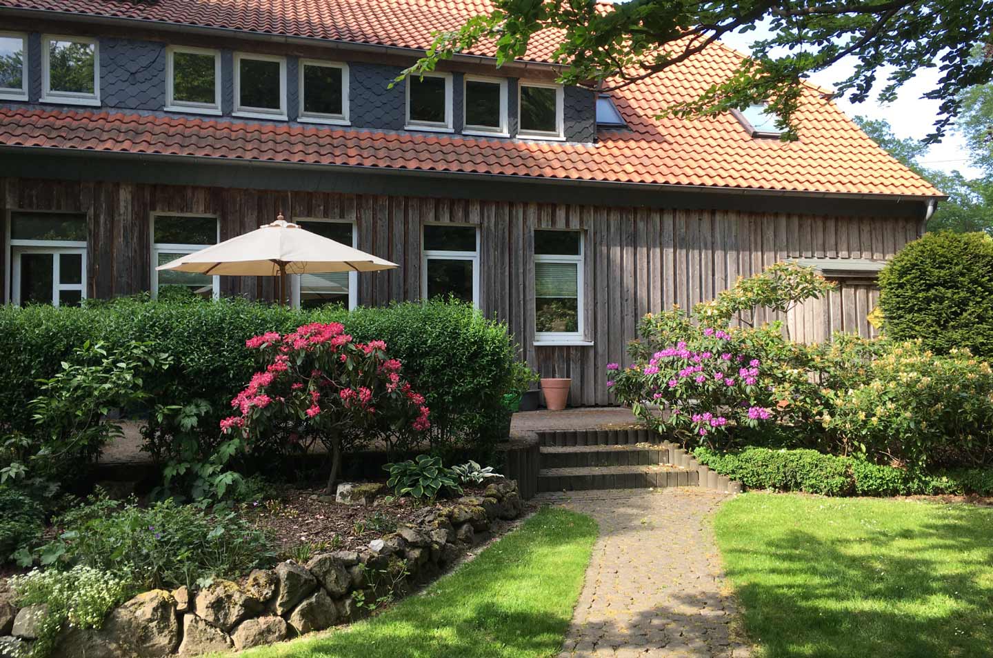 R&uuml;ckseite des HAuses mit Garten und Terrasse